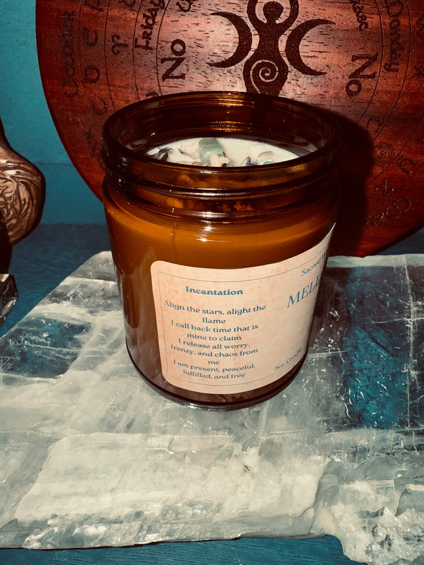 Candle in a glass jar with a label on a crystal surface