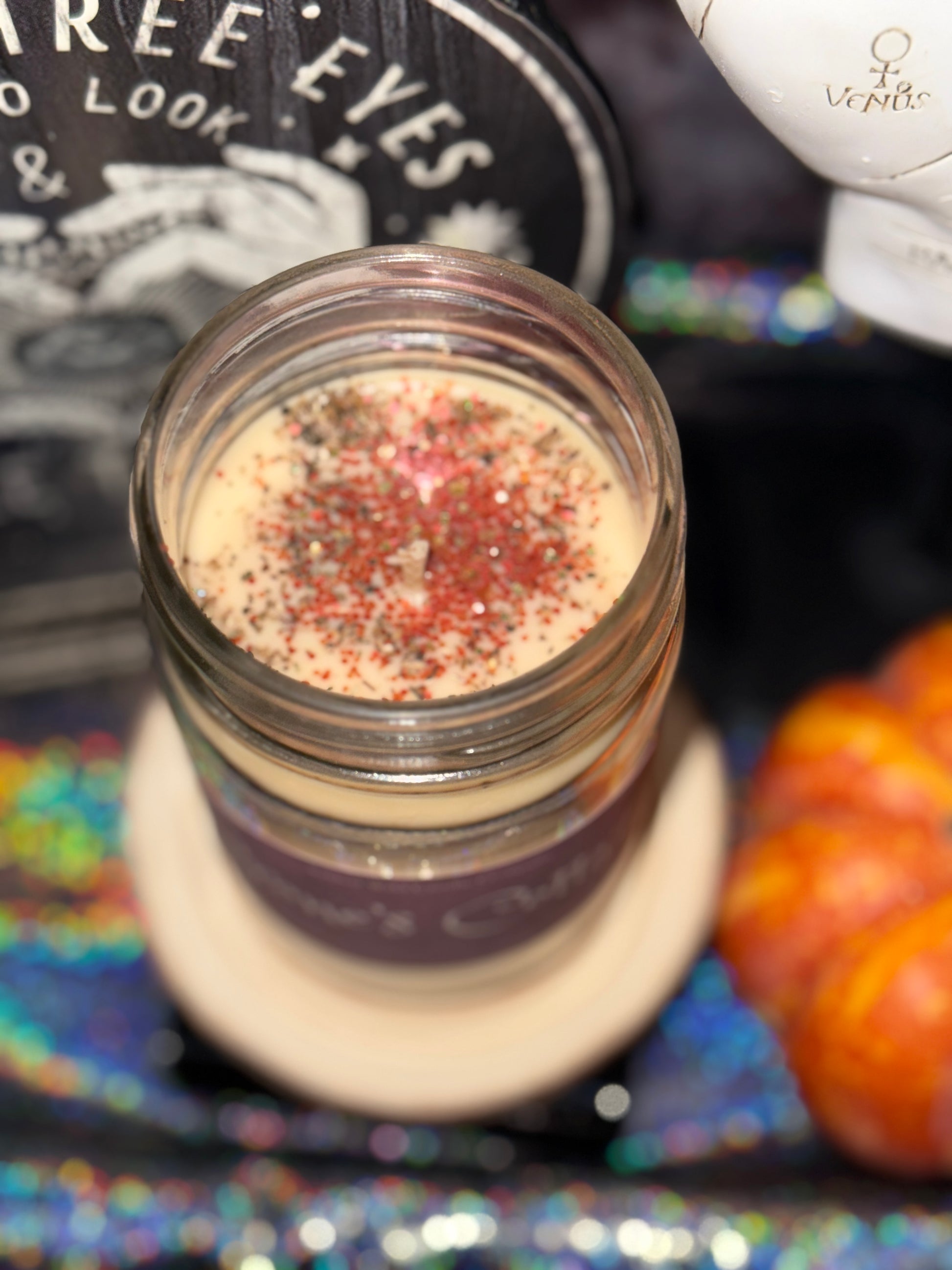 Jar of makeup product with colorful pigments on a decorative background